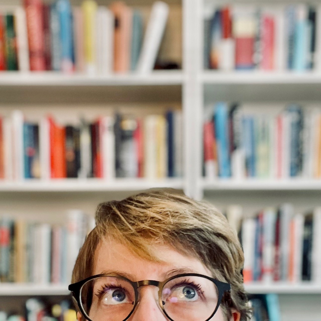 Portrait of myself in front of my bookshelf
